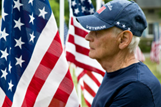veteran standing next ot an American flag